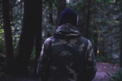 Rear view of man standing in forest