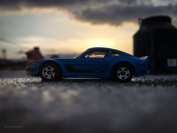 Toy car on road against sky during sunset