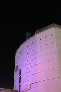 Low angle view of illuminated building against sky at night