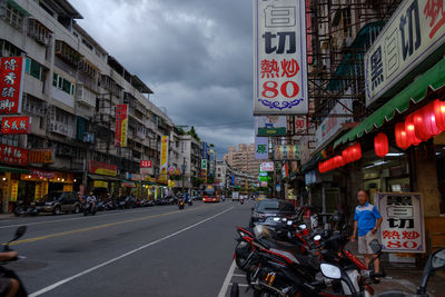 Vehicles on road against buildings in city