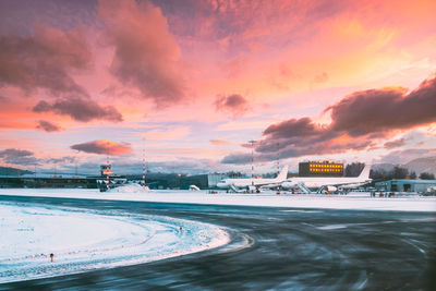 Scenic view of snow covered field against sky during sunset