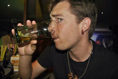 Portrait of young man drinking glass