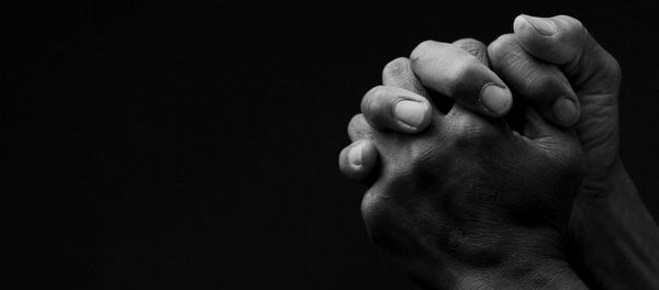 Black man praying to god on gray background with people stock image stock photo