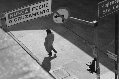 High angle view of man walking on road sign