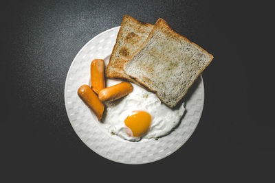 High angle view of breakfast served in plate over black background