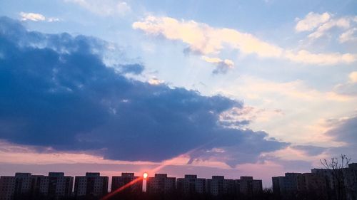 Low angle view of modern buildings against cloudy sky