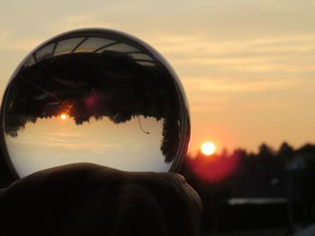 Close-up portrait of man against orange sky