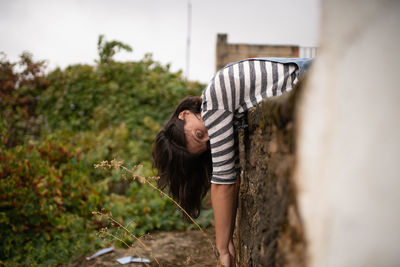 Portrait of woman leaning on retaining wall