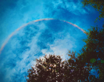 Low angle view of rainbow against blue sky