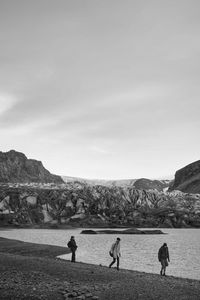 People walking on mountain against sky