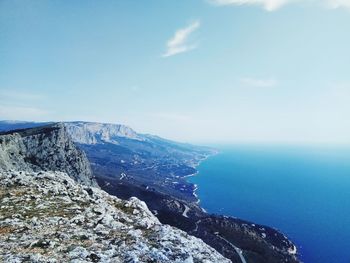 Scenic view of sea and mountains against sky