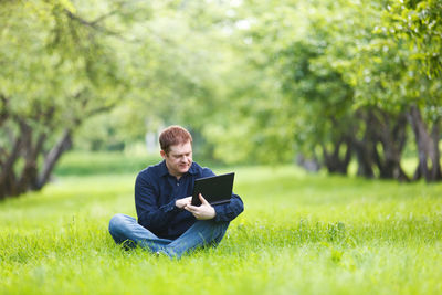 Portrait of happy girl relaxing on grassy field