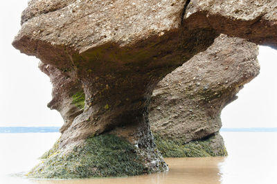 Rock formation in sea against sky