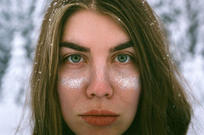 Close-up portrait of woman with snow on face