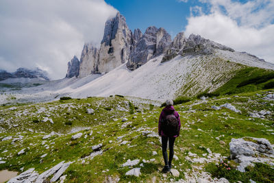 Rear view of person on snowcapped mountains against sky