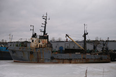 Cranes at commercial dock against sky