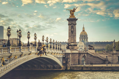 Sculpture of bridge over river against buildings in city