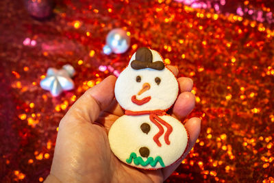 Close-up of hand holding gingerbread cookie during christmas