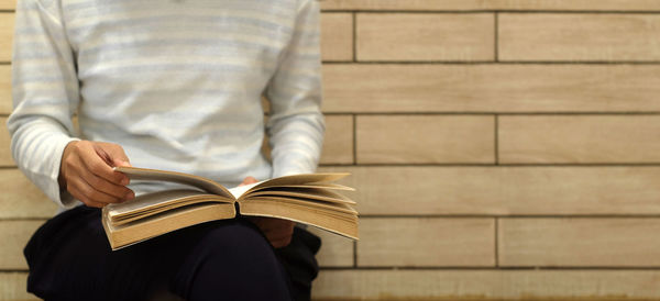 Midsection of man holding book