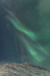 Low angle view of snowcapped mountain against sky at night