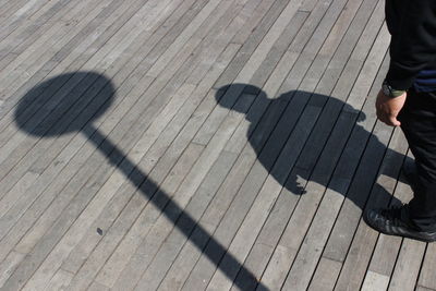 Low section of man standing on boardwalk