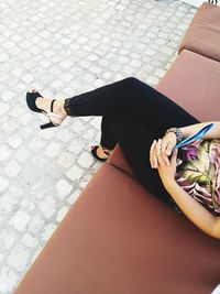 Low section of woman sitting on tiled floor