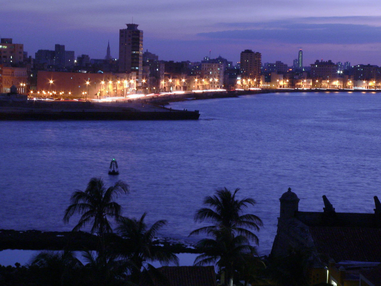 ILLUMINATED CITY BY SEA AGAINST SKY