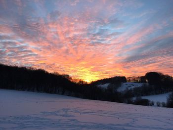 Scenic view of snow landscape against sky during sunset