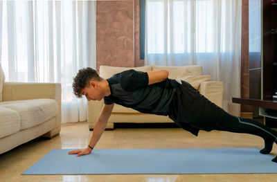 Side view of man lying on sofa at home