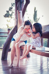 Mother and daughter sitting outdoors