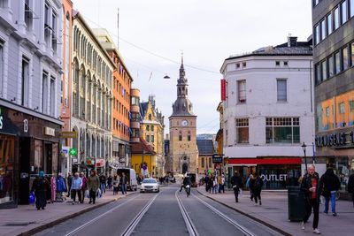 People on street in city against sky
