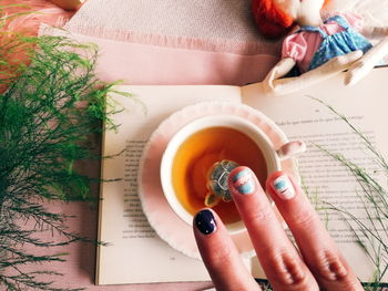 Cropped image of person holding tea cup on table