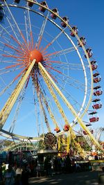 Low angle view of ferris wheel against blue sky