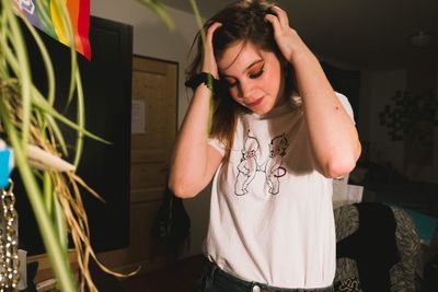 Portrait of young woman standing at home