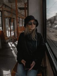 Portrait of young woman sitting on street