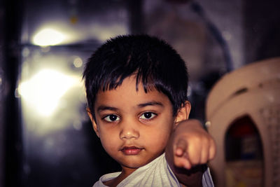 Portrait of cute boy pointing while at home