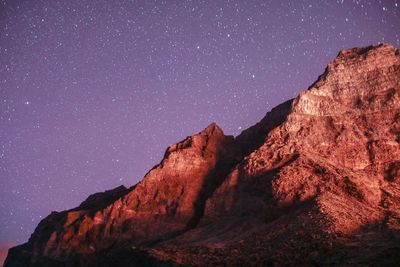 Rock formation against sky at night