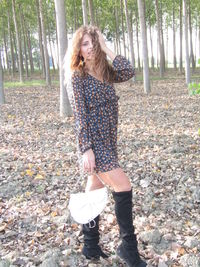 Full length portrait of woman standing in forest