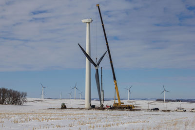 Traditional windmill by sea against sky