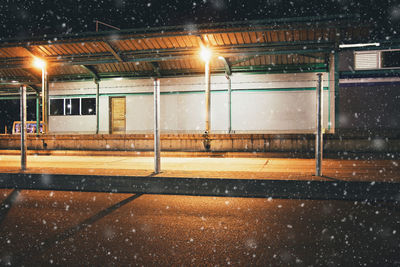 Illuminated street lights on road during snowfall