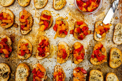 Bruschetta toasts on baking sheet  and spread with gourmet oil and pepper topping