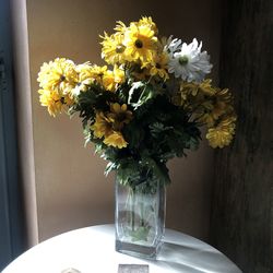 Close-up of yellow flower vase on table next to window