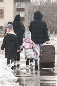 Rear view of people walking on street