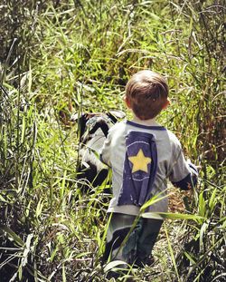 Rear view of boy standing on field