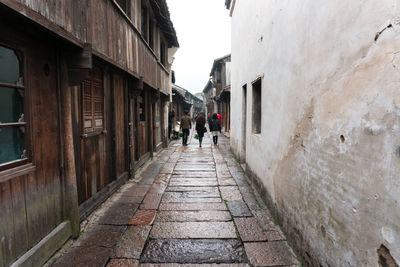 People walking on footpath amidst buildings in city