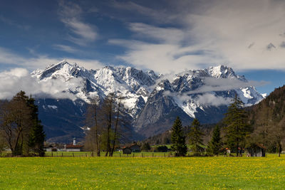 Scenic view of field and mountains against sky