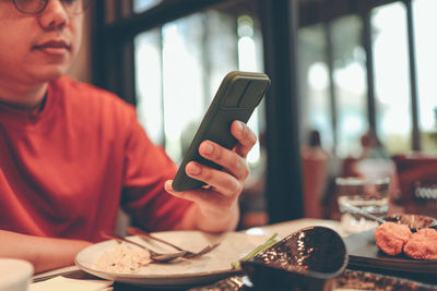 Midsection of man using mobile phone