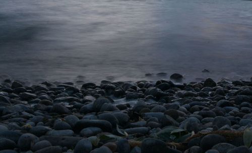 Stones on beach against sky