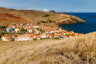 Scenic view of townscape by sea against sky