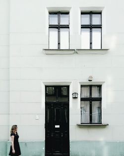 Woman standing on sidewalk in city